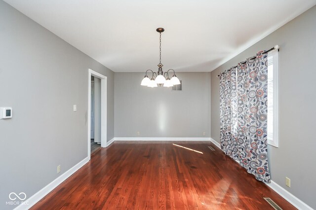 1310 Bowman Dr, Greenfield, IN 46140 - unfurnished room featuring a notable chandelier, wood finished floors, and baseboards