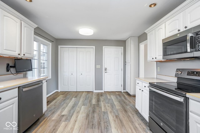 1310 Bowman Dr, Greenfield, IN 46140 - kitchen featuring light wood finished floors, white cabinetry, stainless steel appliances, and light countertops