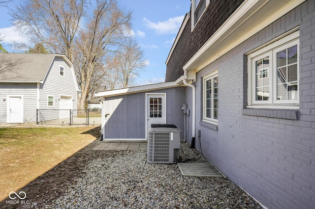 1310 Bowman Dr, Greenfield, IN 46140 - view of property exterior featuring brick siding, fence, central AC unit, a lawn, and a gate
