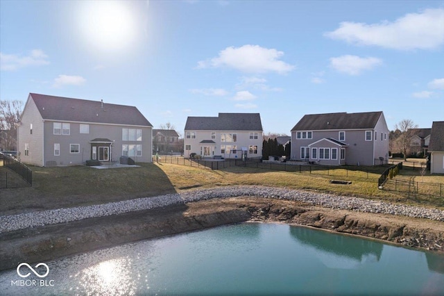 view of pool with a residential view, a lawn, fence, and a water view