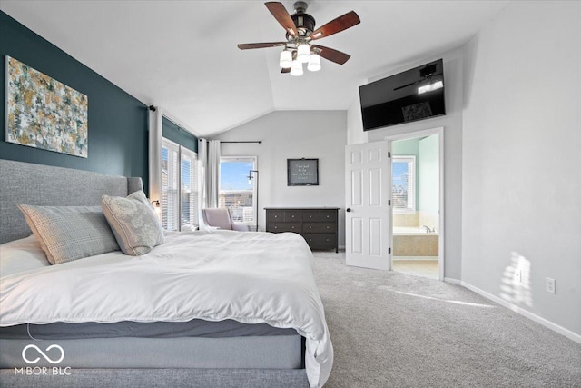 carpeted bedroom with ensuite bath, a ceiling fan, baseboards, and vaulted ceiling