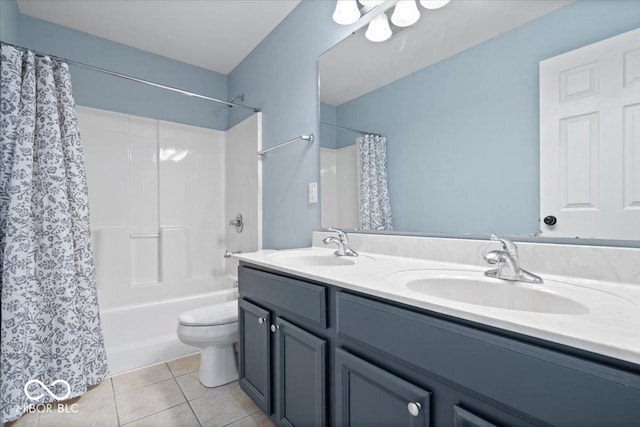 bathroom featuring tile patterned flooring, double vanity, toilet, and a sink