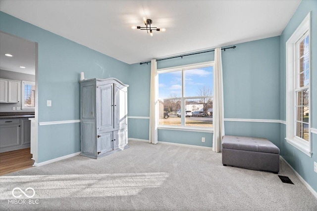 interior space with visible vents, baseboards, and light carpet