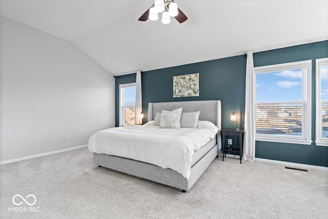 bedroom with vaulted ceiling, multiple windows, carpet, and visible vents