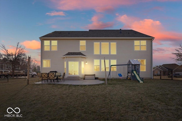 back of property with a patio, a lawn, a fenced backyard, and a playground