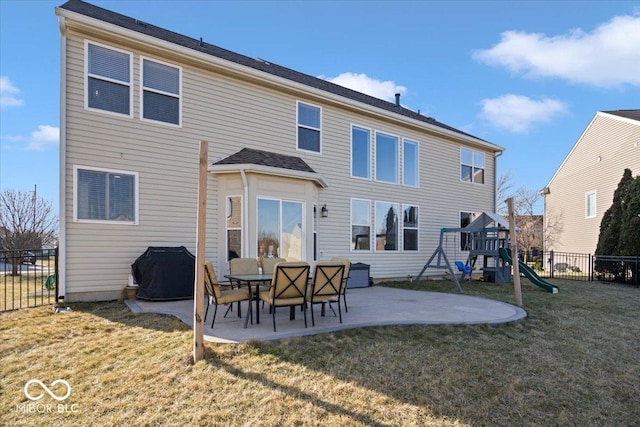 rear view of property with a playground, a yard, a patio area, and fence