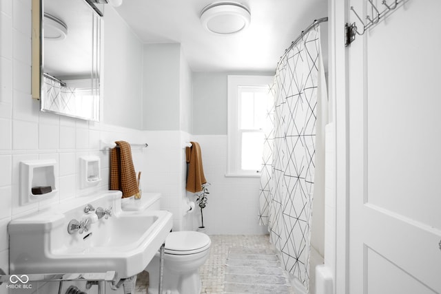 5426 Broadway St, Indianapolis, IN 46220 - bathroom with a shower with shower curtain, toilet, wainscoting, tile walls, and a sink