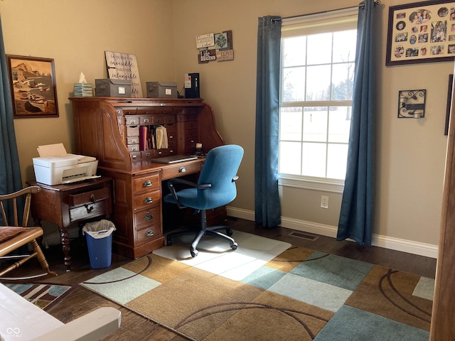 office space with a wealth of natural light, visible vents, and dark wood-style floors