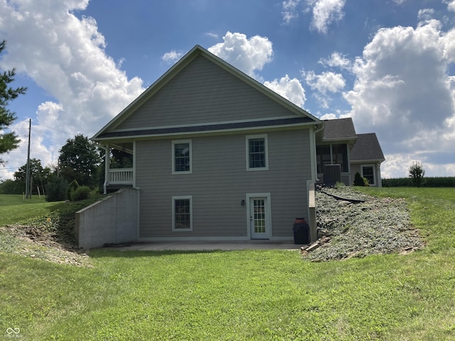 back of property featuring a patio area, a lawn, and central AC