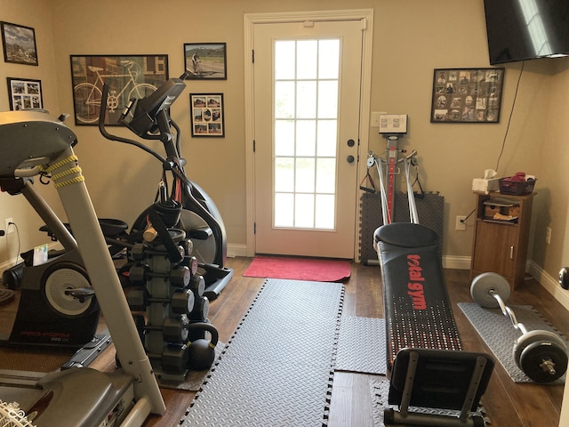 exercise area featuring wood finished floors and baseboards