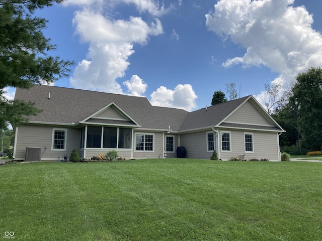 single story home featuring cooling unit, a shingled roof, a front lawn, and a sunroom