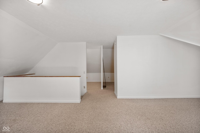 bonus room with lofted ceiling and carpet flooring