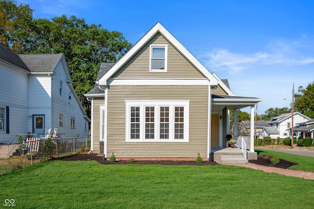 view of front of house with a front lawn, fence, and covered porch