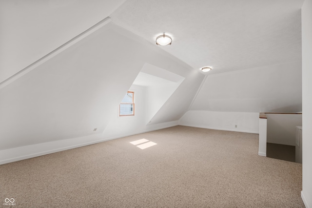 bonus room with carpet floors and vaulted ceiling