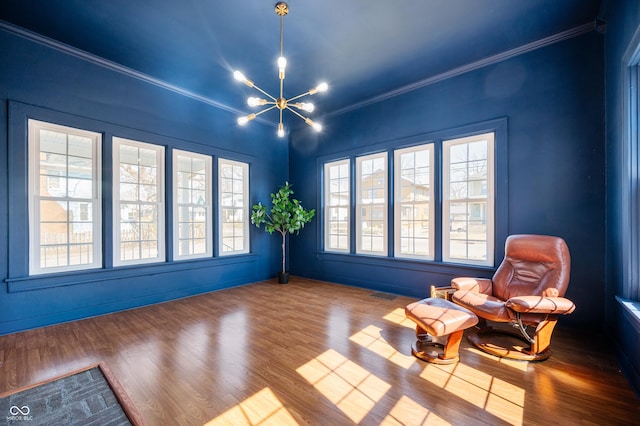 living area featuring visible vents, crown molding, an inviting chandelier, and wood finished floors