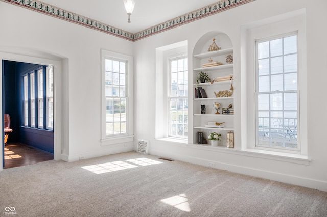 unfurnished dining area with visible vents, baseboards, and carpet