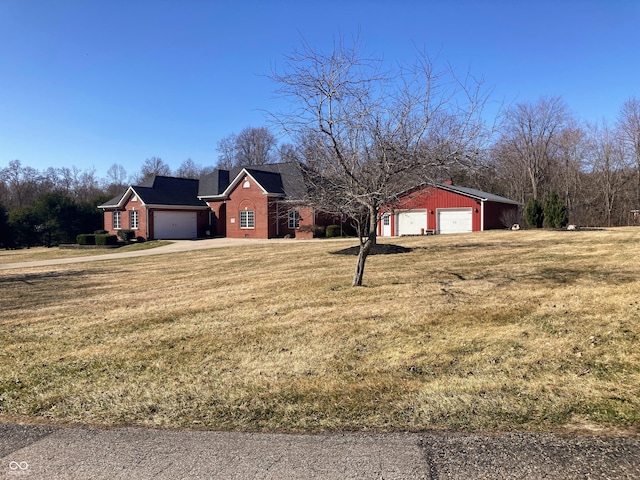 exterior space with a front lawn, a garage, brick siding, and driveway