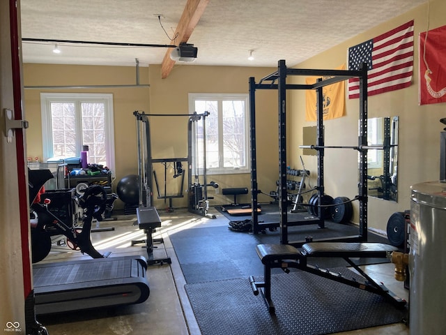 workout area with gas water heater and a textured ceiling