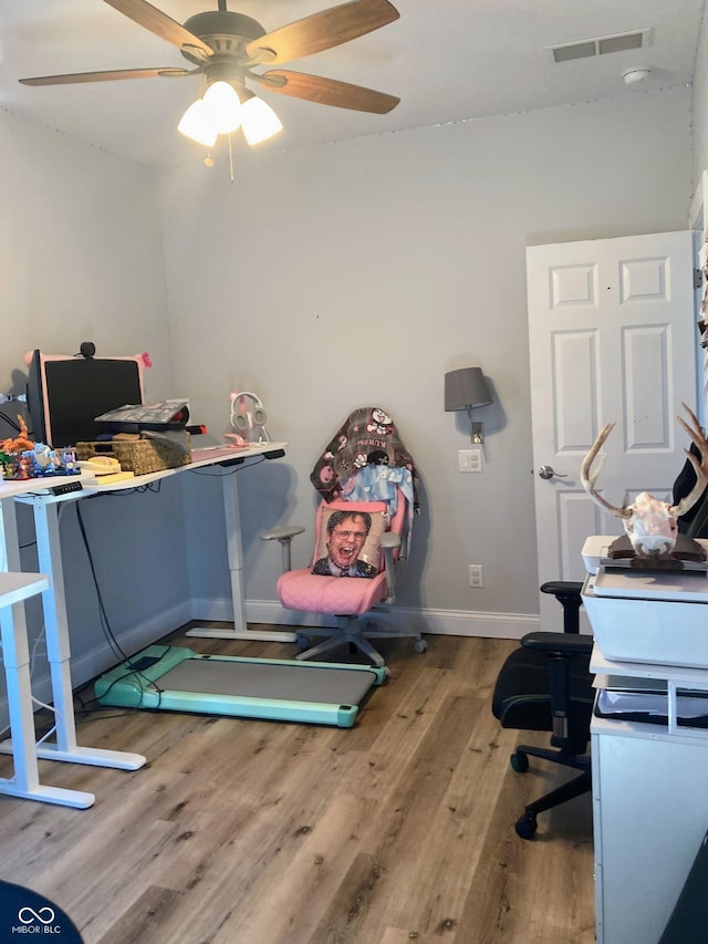 office area with a ceiling fan, wood finished floors, visible vents, and baseboards