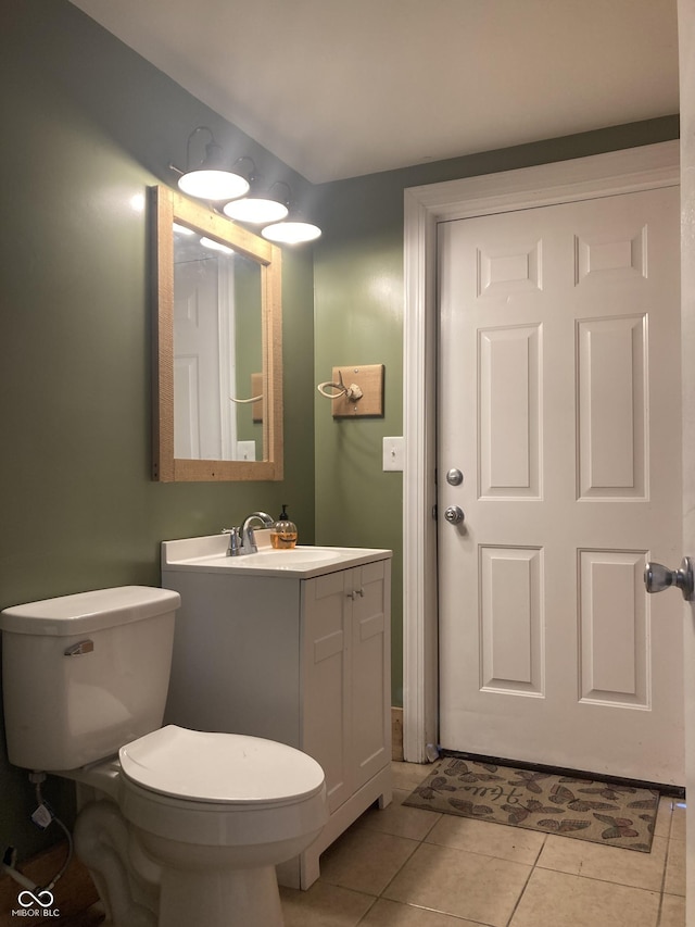 half bath featuring tile patterned flooring, toilet, and vanity