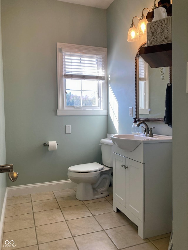 bathroom with tile patterned flooring, toilet, vanity, and baseboards