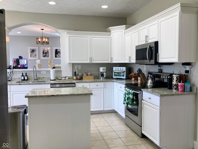 kitchen featuring white cabinets, stainless steel appliances, and a sink