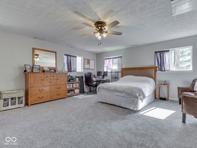 bedroom with carpet, ceiling fan, and a textured ceiling