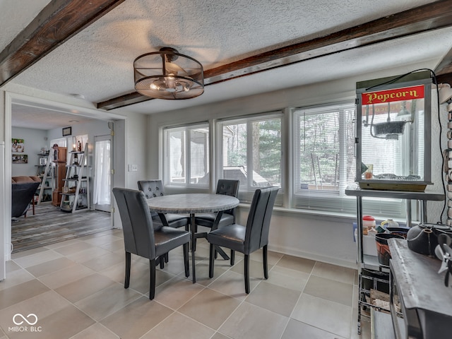 dining area with beam ceiling, light tile patterned floors, a textured ceiling, and baseboards