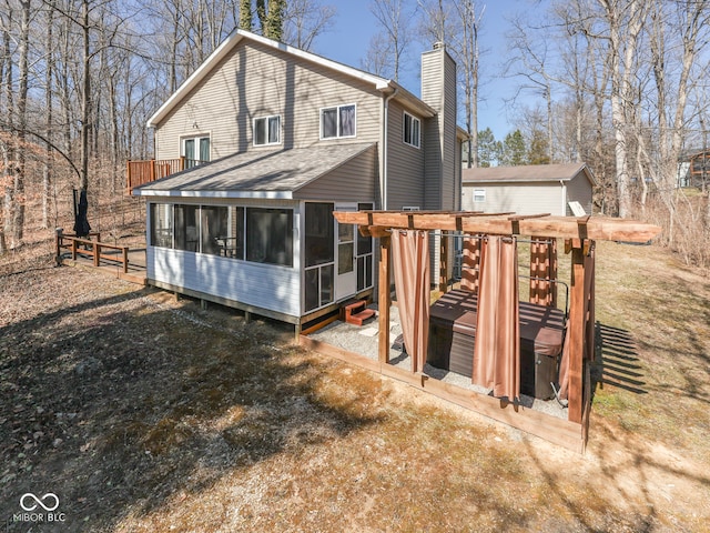 back of house featuring a chimney, fence, and a sunroom