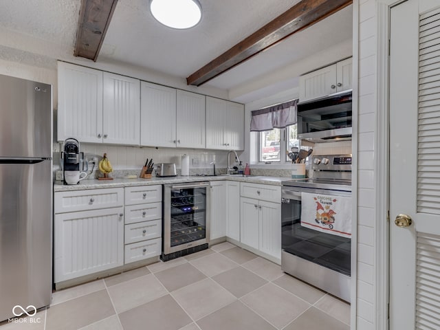 kitchen with wine cooler, beam ceiling, white cabinets, and appliances with stainless steel finishes