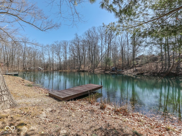 view of dock featuring a forest view and a water view