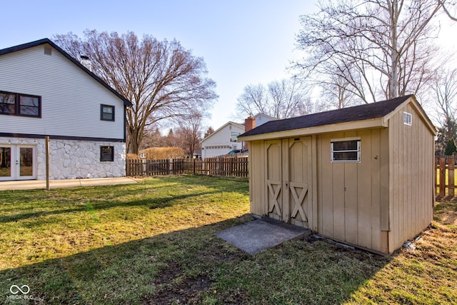 view of yard featuring an outbuilding, fence, and a shed