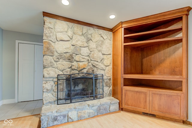 room details with wood finished floors, visible vents, baseboards, recessed lighting, and a stone fireplace