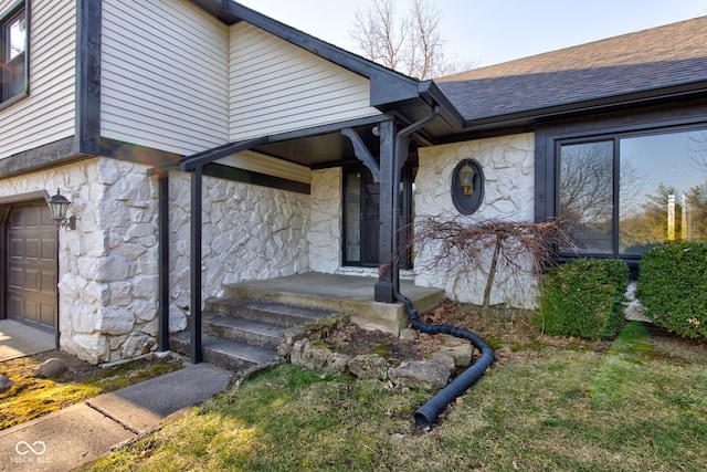 doorway to property featuring stone siding and roof with shingles