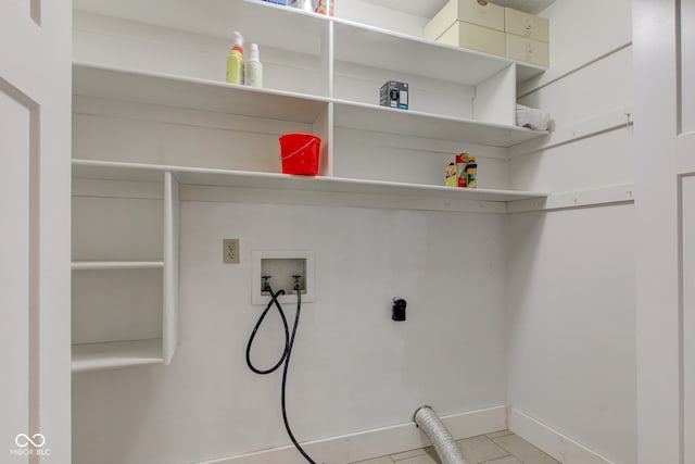 clothes washing area with washer hookup, light tile patterned floors, baseboards, hookup for an electric dryer, and laundry area