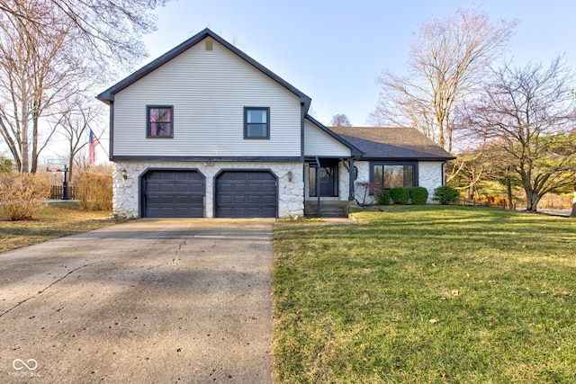 tri-level home with roof with shingles, an attached garage, concrete driveway, a front lawn, and stone siding