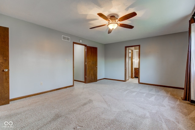 unfurnished bedroom with light colored carpet, baseboards, visible vents, and ensuite bathroom