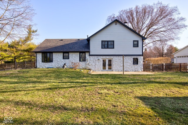 back of property featuring a patio, french doors, stone siding, and a fenced backyard