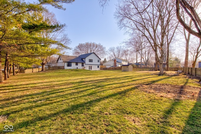 view of yard featuring a fenced backyard, a storage shed, and an outdoor structure