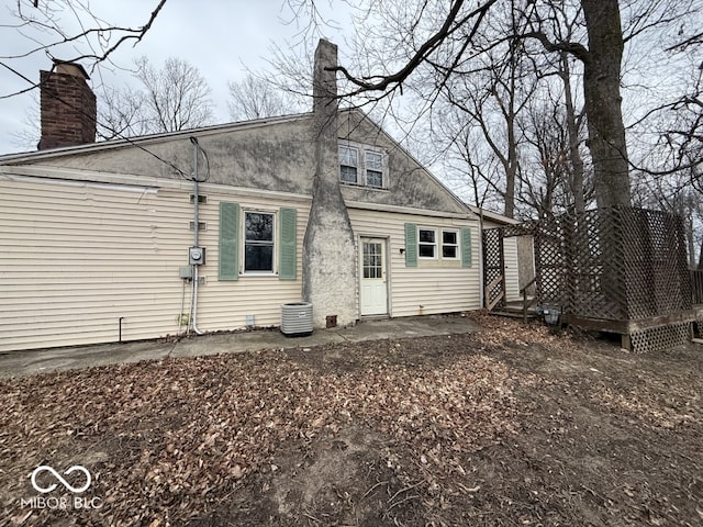 back of house with a chimney and a deck