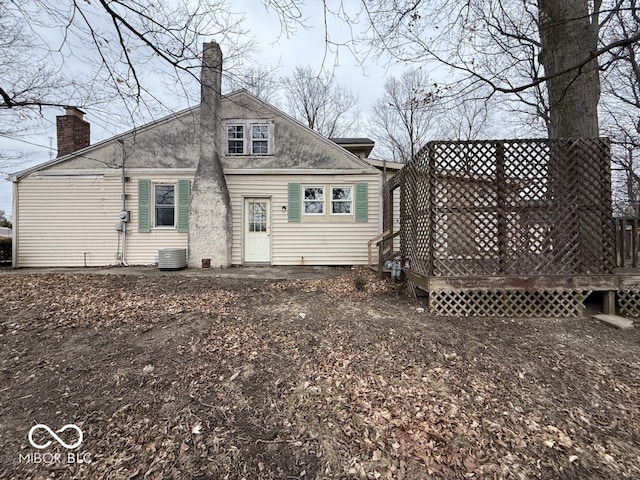 back of property featuring a wooden deck, central AC unit, and a chimney