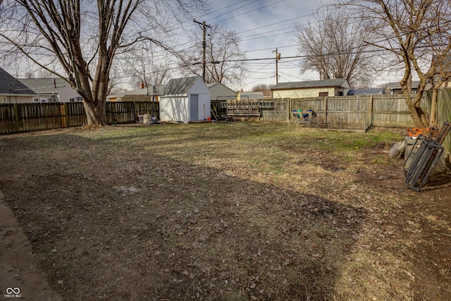 view of yard with an outbuilding, a storage unit, and a fenced backyard