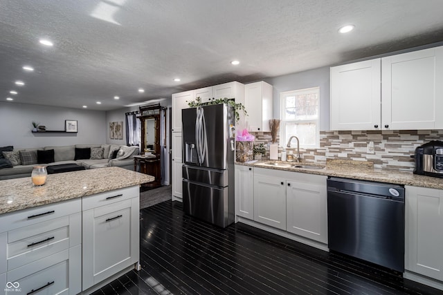 kitchen with a sink, tasteful backsplash, stainless steel fridge, dishwashing machine, and dark wood-style flooring