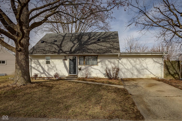 view of front of property featuring entry steps, a front lawn, roof with shingles, and fence