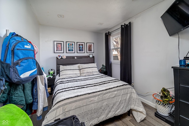 bedroom with wood finished floors and baseboards