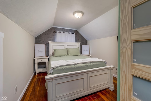 bedroom featuring dark wood-type flooring, baseboards, and vaulted ceiling