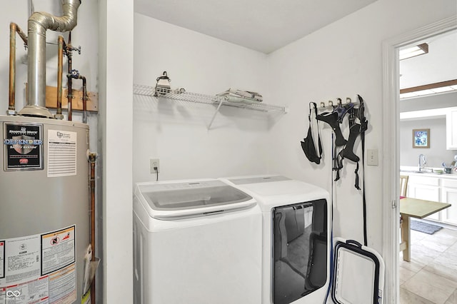 laundry area featuring laundry area, washer and clothes dryer, a sink, and water heater