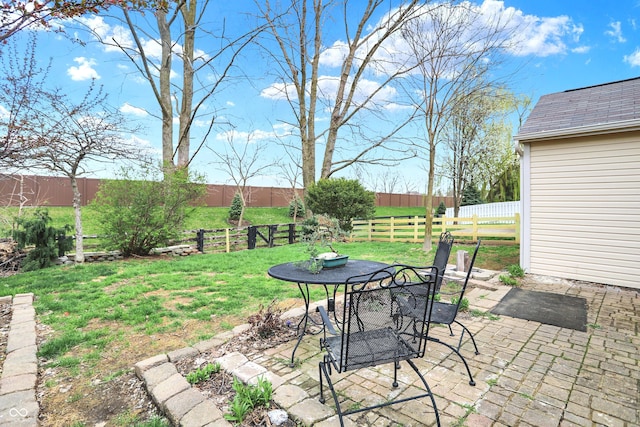 view of yard featuring a patio area, a fenced backyard, and outdoor dining area