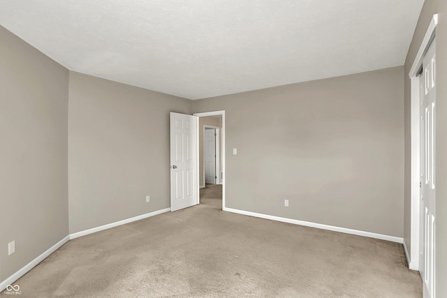 unfurnished bedroom with light colored carpet and baseboards