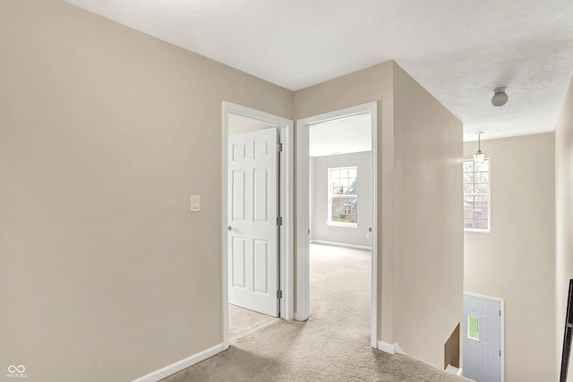 corridor with light colored carpet and baseboards